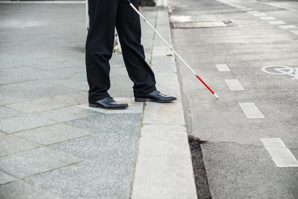 Low Section Of A Blind Person Crossing Street