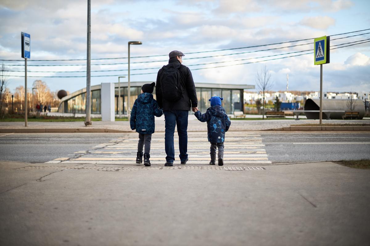 a family crosses the road on a pedestrian crossing