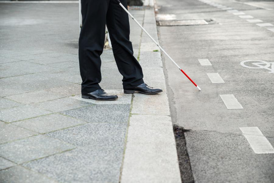 Low Section Of A Blind Person Crossing Street