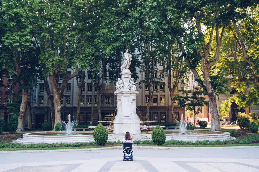 Woman Sitting in Front of a Fountain in Spain