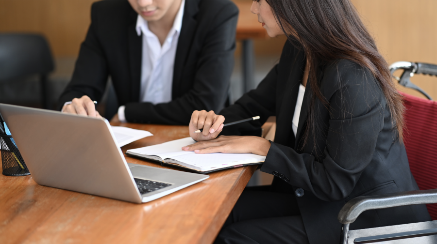 Woman in Wheelchair Working with Colleague