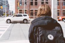 girl with backpack trying to cross street