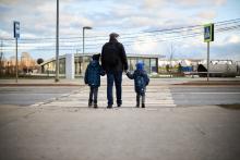 a family crosses the road on a pedestrian crossing
