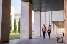 Two Students Walking Around A College Campus